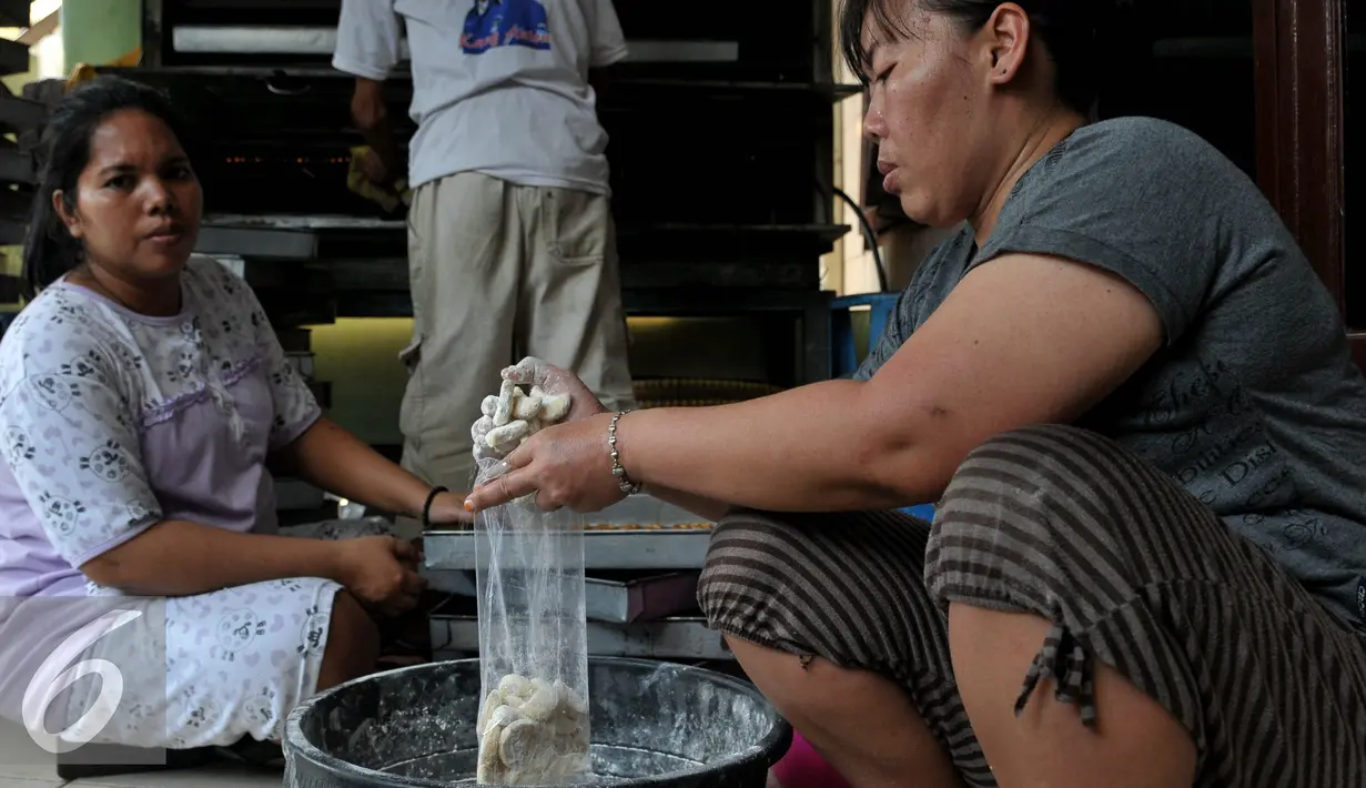 Pekerja tampak memasukkan kue yang telah jadi ke dalam plastik, Jakarta, Rabu (8/7/2015). Menjelang Hari Raya Idul Fitri permintaan kue kering mengalami lonjakan hingga 100 persen dibandingkan dengan hari biasa. (Liputan6.com/JohanTallo)