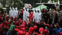 Polisi mengamankan aksi ratusan buruh dari FSMPI dan Perwakilan Daerah KSPI terlibat saling dorong dengan polisi di depan Balai Kota DKI Jakarta, Senin (29/11/2021). Buruh menuntut Gubernur DKI Jakarta Anies Baswedan membatalkan Upah Minimum Provinsi (UMP) Jakarta 2022. (Liputan6.com/Faizal Fanani)