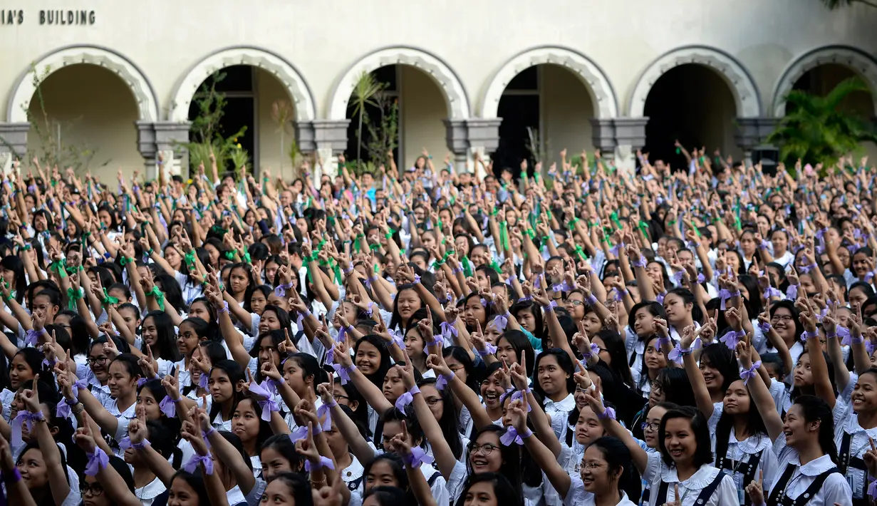 Aksi siswa St. Scholastica College mengacungkan jari telunjuk "nomor satu" saat menari massal dalam gerakan One Billion Rising di Filipina, Senin (15/2). Gerakan ini bentuk kampanye untuk menghentikan kekerasan terhadap perempuan. (AFP PHOTO/Noel CELIS)