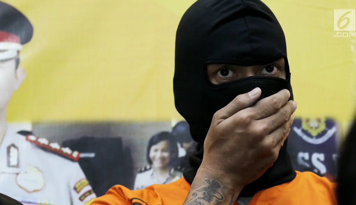 Aktor Tora Sudiro (kenakan penutup wajah hitam) saat dihadirkan dalam jumpa pers kepemilikan psikotropika di Mapolres Jakarta Selatan, Jumat (04/08). Tora dijerat dengan UU Psikotropika tahun 1997 pasal 62. (Liputan6.com/Herman Zakharia)