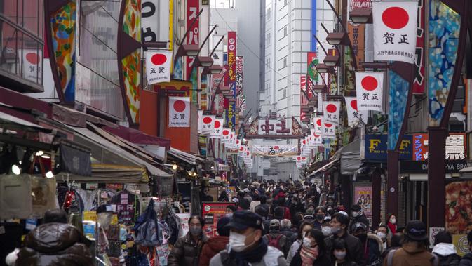 Orang-orang membeli makanan dan perlengkapan untuk merayakan Tahun Baru di distrik perbelanjaan Ueno di Tokyo, Selasa (29/12/2020). Tokyo melaporkan peningkatan kasus virus corona menjelang musim libur tahun baru, dimana biasanya masyarakat yang tinggal di ibu kota akan mudik. (Kazuhiro NOGI/AFP)
