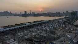 Foto udara menunjukkan lokasi pembangunan fasilitas isolasi sementara untuk menampung pasien Covid-19 yang sedang dibangun di Terminal Kapal Pesiar Kai Tak, Hong Kong (6/4/2022). Bangunan tersebut akan berisi 1.000 tempat tidur dan diharapkan bisa mengurangi beban di rumah sakit umum. (AFP/Yan Zhao)