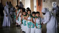 Murid TK berbaris saat mengikuti edukasi manasik haji anak di Masjid At-Tin, Jakarta, Selasa (28/2/2023). Manasik haji yang diikuti puluhan murid TK se-Kecamatan Pasar Rebo tersebut dalam rangka mengenalkan rukun Islam kelima yakni ibadah haji serta tata cara melaksanakannya kepada anak sejak usia dini. (Liputan6.com/Faizal Fanani)