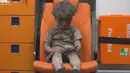 Seorang bocah duduk di dalam ambulans usai diselamatkan dari reruntuhan gedung yang hancur akibat serangan jet tempur milik pemerintah Suriah, Aleppo, Suriah (17/8). (REUTERS)