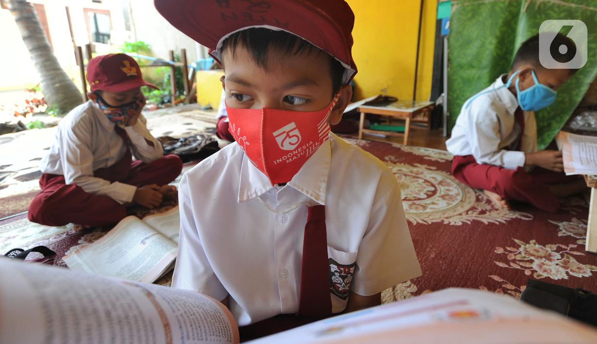 Murid kelas III SDN 02 Pondok Petir mengikuti kegiatan belajar mengajar di teras rumah salah satu siswa di Depok, Senin (31/08/2020). Sudah hampir dua minggu ini, mereka mengadakan pembelajaran secara tatap muka dengan guru yang berkeliling atas permintaan wali murid. (merdeka.com/Arie Basuki)