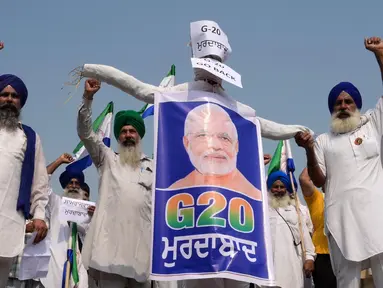 Sejumlah petani membentangkan poster bergambar Perdana Menteri India Narendra Modi dengan logo KTT G20 India selama protes di Amritsar pada tanggal 8 September 2023. (Narinder NANU/AFP)
