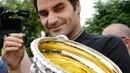 Ekspresi Roger Federer saat memegang trofi Australian Open 2017 di Carlton Gardens di Melbourne, Australia (30/1). Kemenangan Federer di Australian Open 2017 membuat dirinya meraih gelar ke-18 Grand Slam. (AP Photo / Aaron Favila)