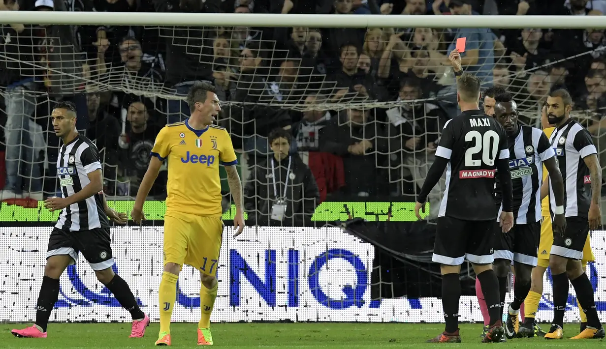 Wasit memberikan kartu merah kepada striker Juventus, Mario Mandzukic, saat melawan Udinese pada laga Serie A Italia di Stadion Friuli, Udine, Minggu (22/10/2017). Udinese kalah 2-6 dari Juventus. (AFP/Miguel Medina)