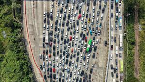 Untuk mengurai kemacetan di Tol Cikampek Utama (Cikatama), Korlantas Polri akan menerapkan one way dari KM 70 Cikatama hingga KM 414 Tol Kalikangkung. Tampak foto udara menunjukkan kendaraan yang terjebak kemacetan di gerbang tol Cikampek Utama 2, Jawa Barat, pada Selasa 17 Maret 2026. (BAY ISMOYO/AFP)