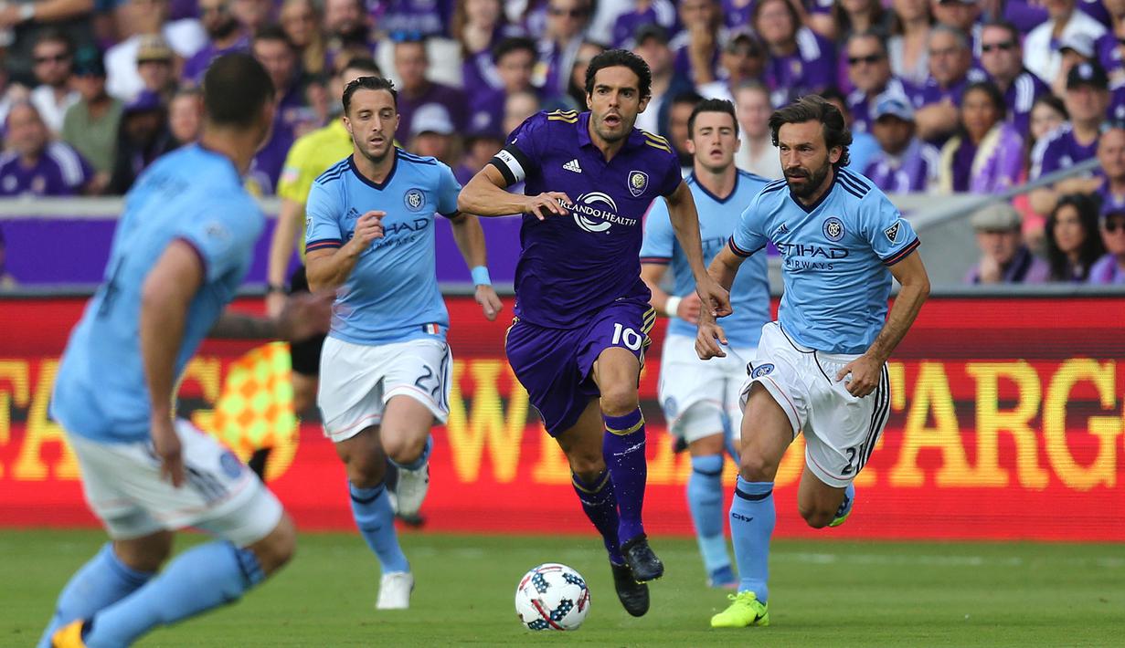 Pemain Orlando City SC, Ricardo Kaka (tengah) berusaha melewati pemain New York City FC, Andrea Pirlo (kanan) dan rekan-rekannya saat laga lanjutan MLS di Orlando City Stadium, Orladndo, Florida, 5 Maret 2017. Kaka tercatat telah mencetak 24 gol dan membuat 19 assist dalam 79 pertandingan sebelum gantung sepatu pada 2017. Sementara Pirlo telah mengemas 1 gol dan 9 assist dalam 62 penampilannya sebelum pensiun pada 2018. (AFP/Getty Images/Alex Menendez)