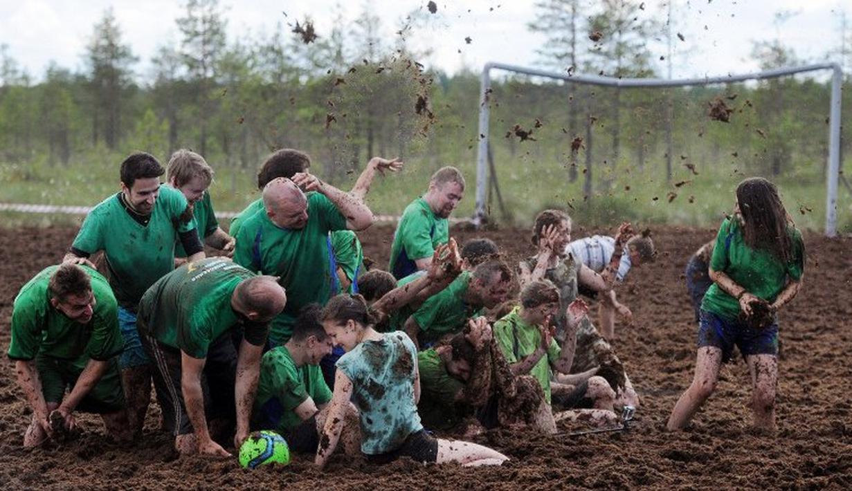Pemain sepak bola rawa berebut bola dalam turnamen memperebutkan Piala Rusia yang berlangsung di Saint Petersburg, Rusia. Sabtu (27/6). (AFP PHOTO/OLGA MALTSEVA)
