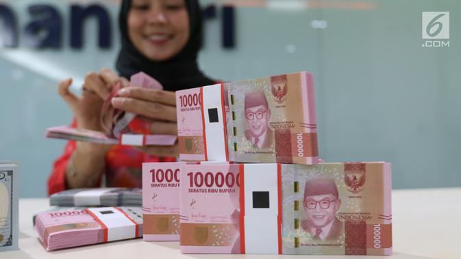 Teller tengah menghitung mata uang rupiah dan dolar di Bank Mandiri, Jakarta, Kamis (10/1). Nilai tukar rupiah terhadap dolar Amerika Serikat (AS) terus menguat di perdagangan pasar spot hari ini. Rupiah berada di zona hijau. (Liputan6.com/Angga Yuniar)