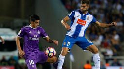 Pemain Real Madrid, James Rodriguez (kiri), berebut bola dengan pemain Espanyol, Leo Baptistao, pada laga La Liga 2016-2017 di Estadio Cornella-El Prat, Senin (19/9/2016) dini hari WIB. (AFP/Pau Barrena)
