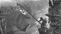 Raising a flag over the Reichstag (Yvegeny Khaldei/Wikipedia)