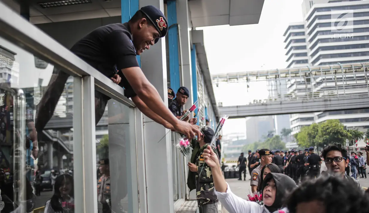 Peserta aksi yang tergabung dalam komunitas Spartan Nusantara membagikan bunga kepada Brimob di sekitar Gedung Bawaslu, Jakarta, Minggu (26/5/2019). Aksi tersebut sebagai bentuk terima kasih kepada TNI/Polri karena setia dan menjaga keamanan NKRI terkait sengketa pemilu. (Liputan6.com/Faizal Fanani)