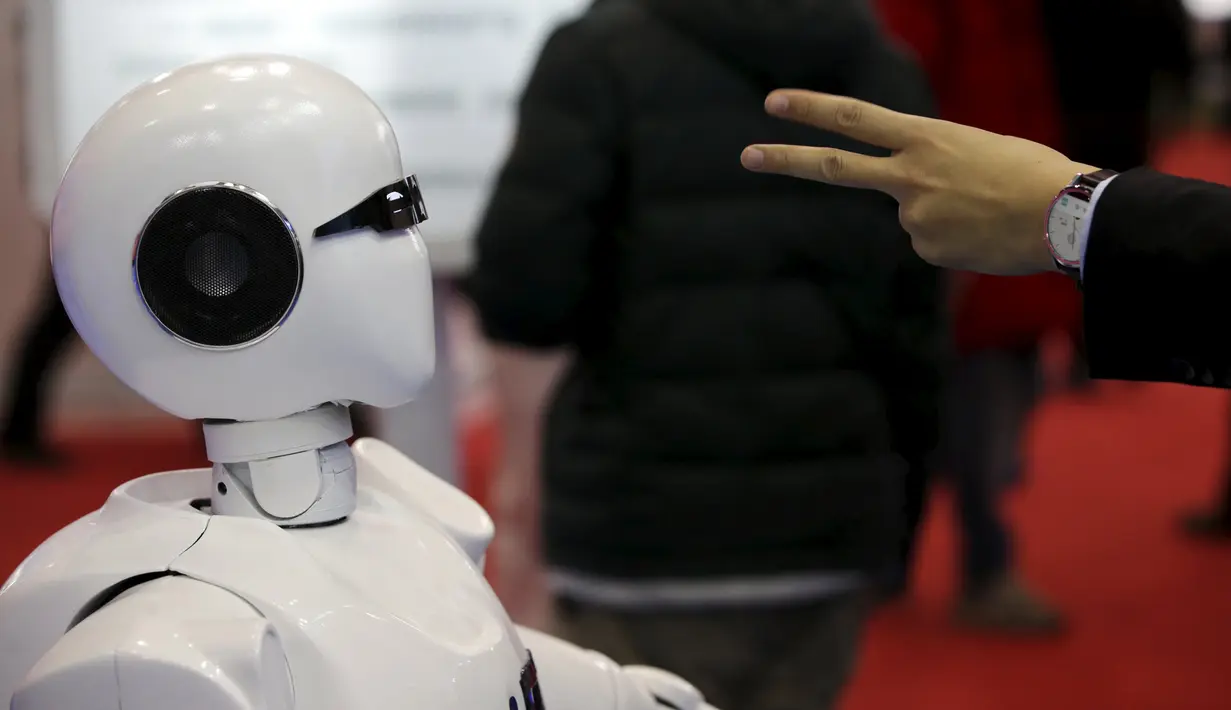 Pengunjung saat berinteraksi dengan KINGER pada Pameran Dunia Robot selama Konferensi Robot Dunia di Beijing, Cina,  (24/11). Selain pameran robot, Acara ini juga mengadakan kontes robot bagi para pelajar dan pemuda. (REUTERS/Jason Lee)