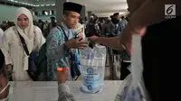 Jemaah haji Kloter 2 asal Banten antre mengambil air zam-zam di Asrama Haji Pondok Gede, Jakarta, Rabu (29/8). Panitia Penyelenggara Ibadah Haji (PPIH) membagikan air zam-zam sebanyak lima liter per jemaah secara cuma-cuma. (Merdeka.com/ Iqbal S. Nugroho)