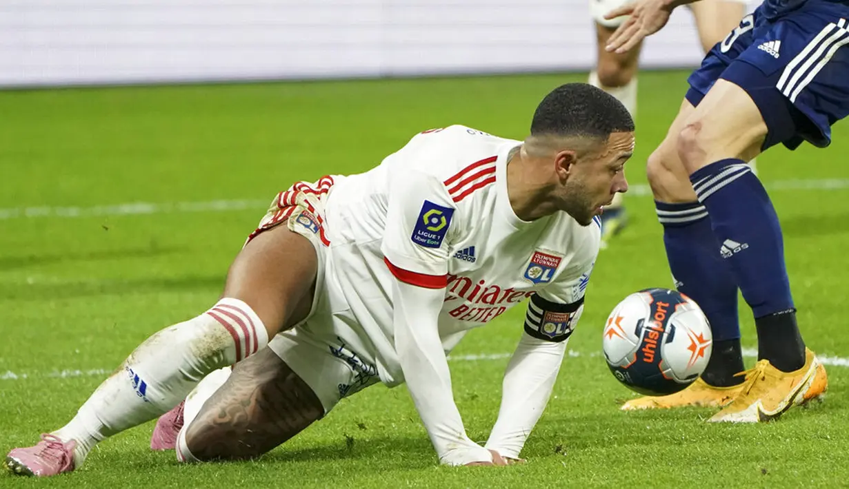 Pemain Lyon Memphis Depay jatuh saat melawan Bordeaux pada pertandingan Liga Prancis di Lyon, Prancis, Jumat (29/1/2021). Lyon menang 2-1 atas Bordeaux dan naik ke puncak klasemen sementara Liga Prancis menyalip Paris Saint-Germain (PSG). (AP Photo/Laurent Cipriani)