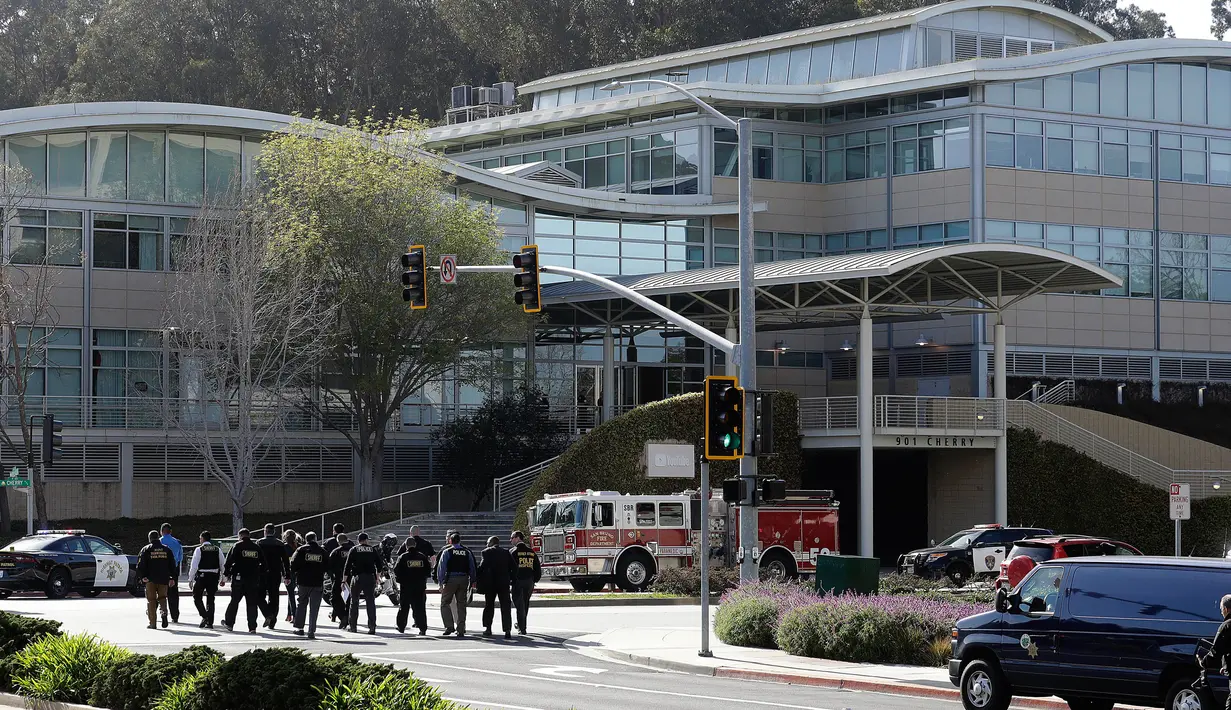 Petugas penegak hukum berjalan menuju kantor pusat YouTube sesaat setelah insiden penembakan di San Bruno, California, Amerika Selatan, Selasa (3/4). Polisi telah menutup seluruh gedung untuk melakukan penyelidikan lebih lanjut. (AP/Jeff Chiu)