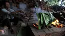 Foto yang diambil 23 Januari 2016 memperlihatkan pekerja tengah membakar daun pisang yang akan digunakan untuk membungkus kue keranjang di pabrik Nyona Lauw di Neglasari, Tangerang. (Liputan6.com/JohanTallo)