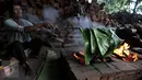 Foto yang diambil 23 Januari 2016 memperlihatkan pekerja tengah membakar daun pisang yang akan digunakan untuk membungkus kue keranjang di pabrik Nyona Lauw di Neglasari, Tangerang. (Liputan6.com/JohanTallo)