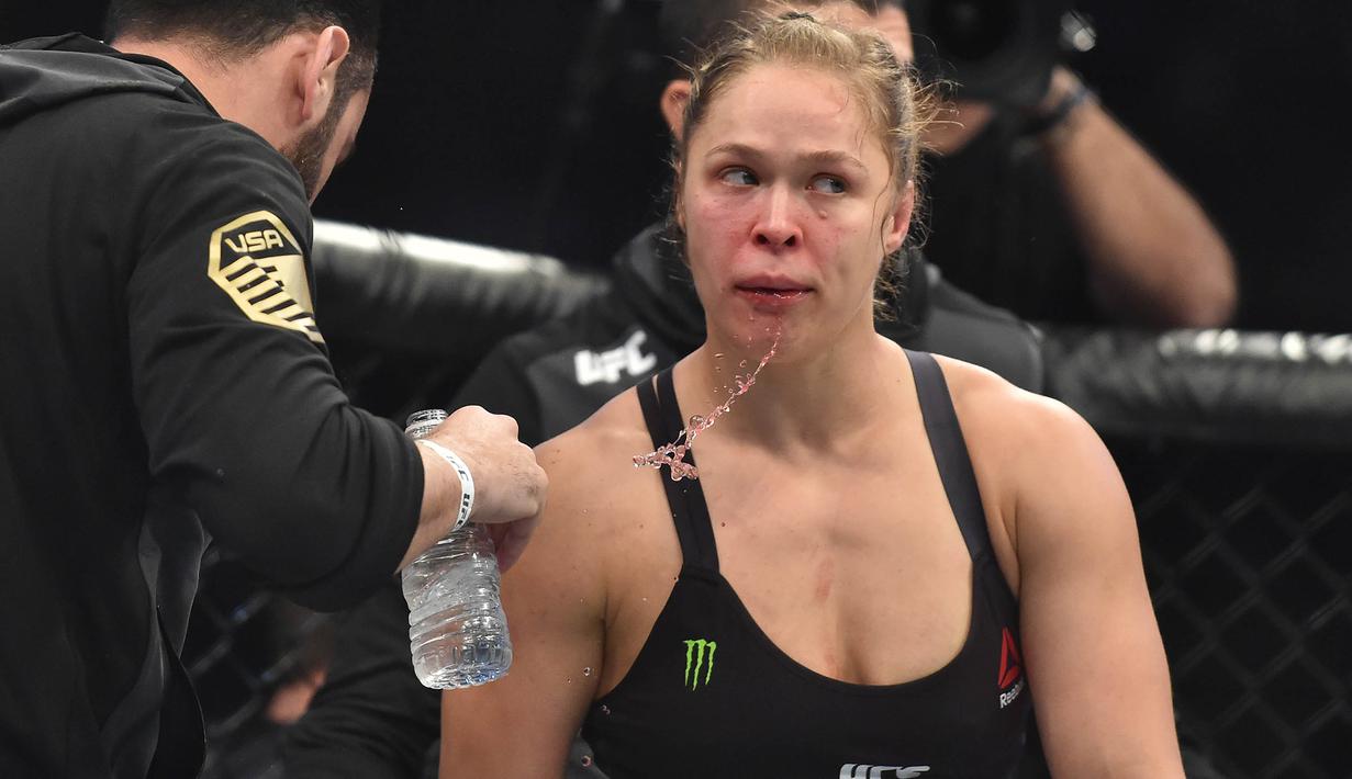Ronda Rousey tampak lelah saat ronde pertama pada pertarungan perebutan gelar juara kelas bantam UFC Women melawan Holy Holm di Stadion Etihad, Melbourne, Minggu (15/11/2015). (AFP Photo/Paul Crock)