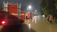 Petugas pemadam kebakaran menguras banjir yang menggenang di Jalan Mayjen Sutoyo Cawang, Rabu (1/1/2020) malam ke Sungai Kalimalang. (Ady Anugrahadi/Liputan6.com)