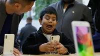 Seorang anak bermain fitur animoji iPhone X di toko Apple Union Square di San Francisco (3/11). iPhone X juga memiliki fitur terbaru Face ID yang berfungsi mendeteksi dan mengenali wajah pemilik sebagai kunci membuka perangkat. (AP Photo/Eric Risberg)