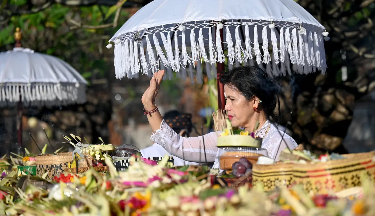<p>Seorang perempuan umat Hindu berdoa saat mengikuti sembahyang perayaan hari raya Galungan di Pura Jagat Natha di Denpasar, Bali, Rabu (8/6/2022). Hari Raya Galungan merupakan hari merayakan kemenangan kebaikan (Dharma) melawan kejahatan (Adharma). (SONNY TUMBELAKA / AFP)</p>