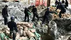 Polisi dari unit pejinak bom menempatkan karung pasir yang mengelilingi bom buatan AS yang dijatuhkan pada Perang Dunia II di persimpangan Convention Avenue dan Hung Hing Road di distrik Wan Chai di Hong Kong (11/5). (Handout / Polisi Hong Kong / AFP)