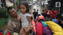 Petugas mengevakuasi anak-anak korban banjir di kawasan Karet Pasar Baru Barat, Jakarta, Selasa (25/2/2020). Banjir yang terjadi sejak subuh akibat luapan Kanal Banjir Barat tersebut merendam ratusan rumah hingga setinggi dua meter. (merdeka.com/Arie Basuki)