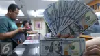 Petugas menunjukkan mata uang Dolar Amerika di toko penukaran uang di Jakarta, Selasa (7/6). Dolar AS kembali melemah terhadap rupiah. Mata uang Paman Sam ini bergerak dikisaran Rp 13.300. (Liputan6.com/Angga Yuniar)