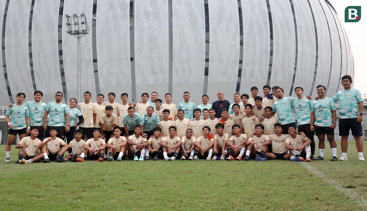 Para pemain dan ofisial tim Timnas Indonesia U-16 yang dipersiapkan untuk ajang Piala AFF U-16 2024 berfoto bersama pelatih Nova Arianto usai menjalani latihan di lapangan latihan Jakarta International Stadium (JIS), Jakarta, Minggu (31/03/2024) sore. (Bola.com/Abdul Aziz)