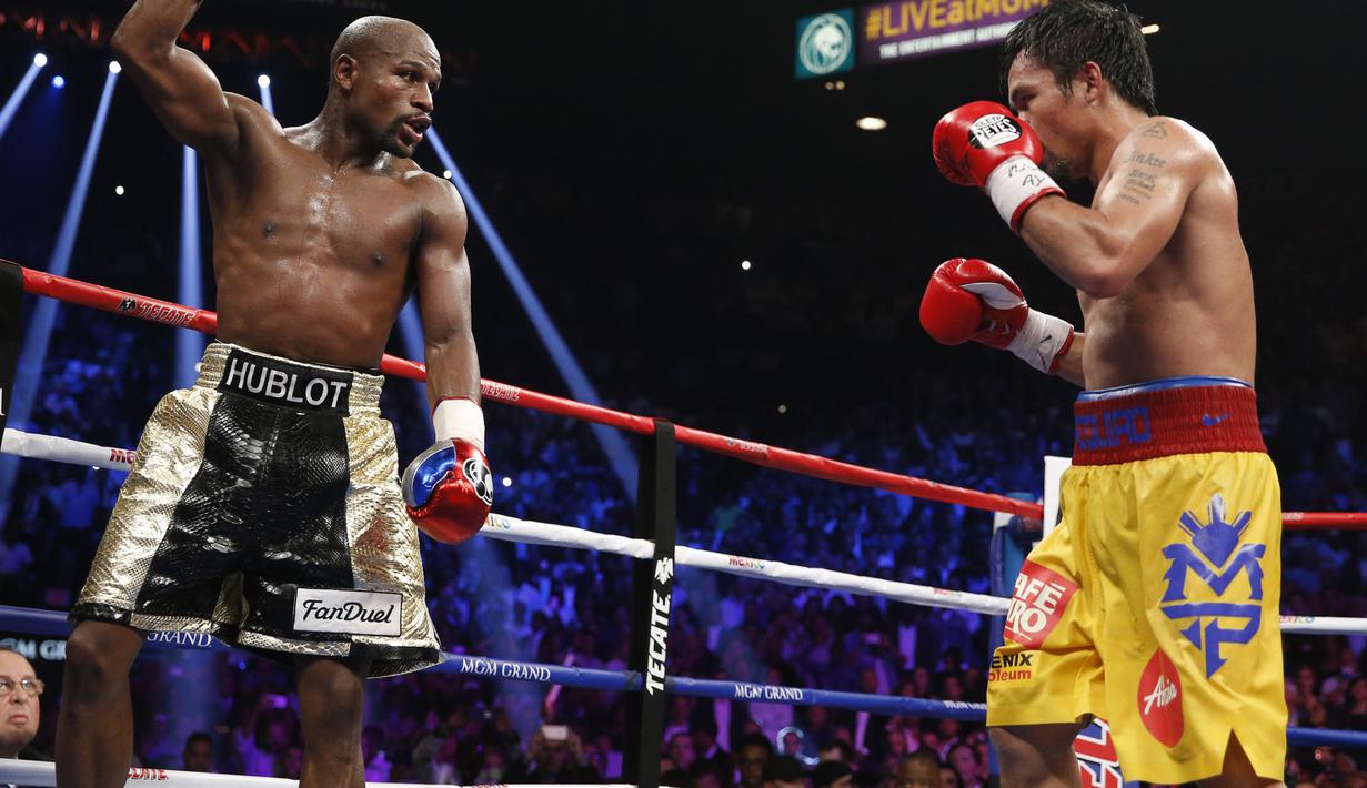 Mayweather Jr. tengah mengambil mengalihkan perhatian Pacquiao dengan mengangkat tangannya. (AP Photo/John Locher)
