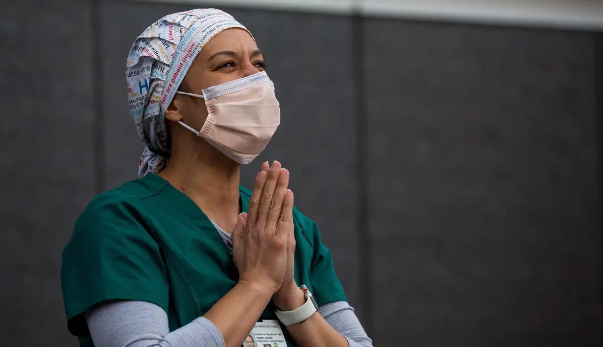 Samantha Giambalvo, seorang perawat dari Alabama yang bertugas di New York sejak 6 April, menyaksikan para pemadam kebakaran dan warga yang menunjukkan apresiasi mereka terhadap petugas medis di depan Langone Medical Center NYU di New York, Amerika Serikat, pada 9 Mei 2020.  (Xinhua/Michael Nagle)