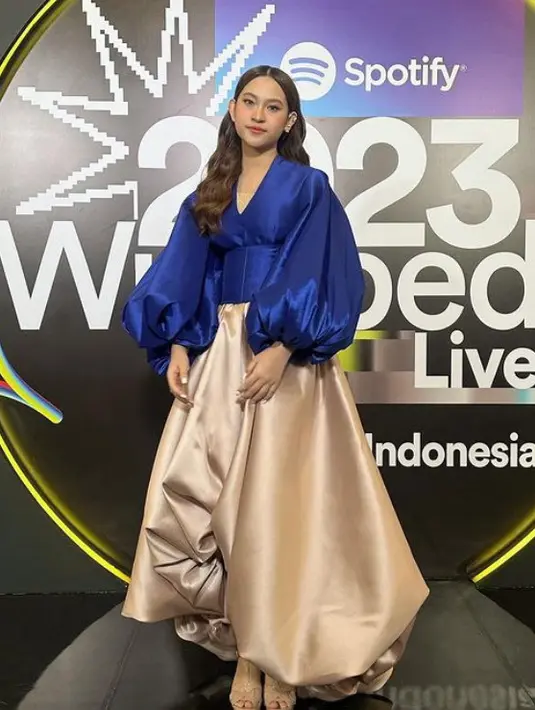 Raissa Anggiani tampil dengan atasan lengan panjang balon warna biru serasi dengan obinya. Dipadukan rok warna beige. [@raissanggiani]