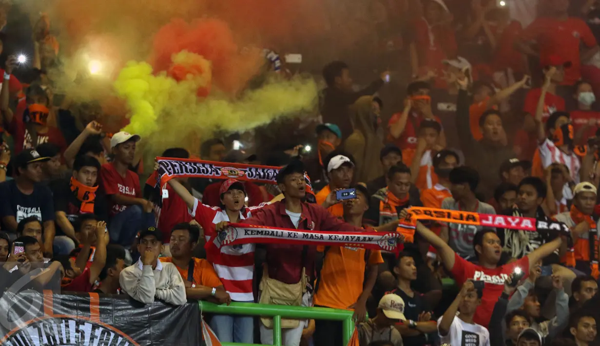 Suporter membentangkan syal usai menyaksikan laga Persija melawan Timnas Indonesia U-22 di Stadion Patriot Candrabhaga, Bekasi, Rabu (5/4). Laga Persija melawan Timnas Indonesia U-22 berakhir imbang 0-0. (Liputan6.com/Helmi Fithriansyah)