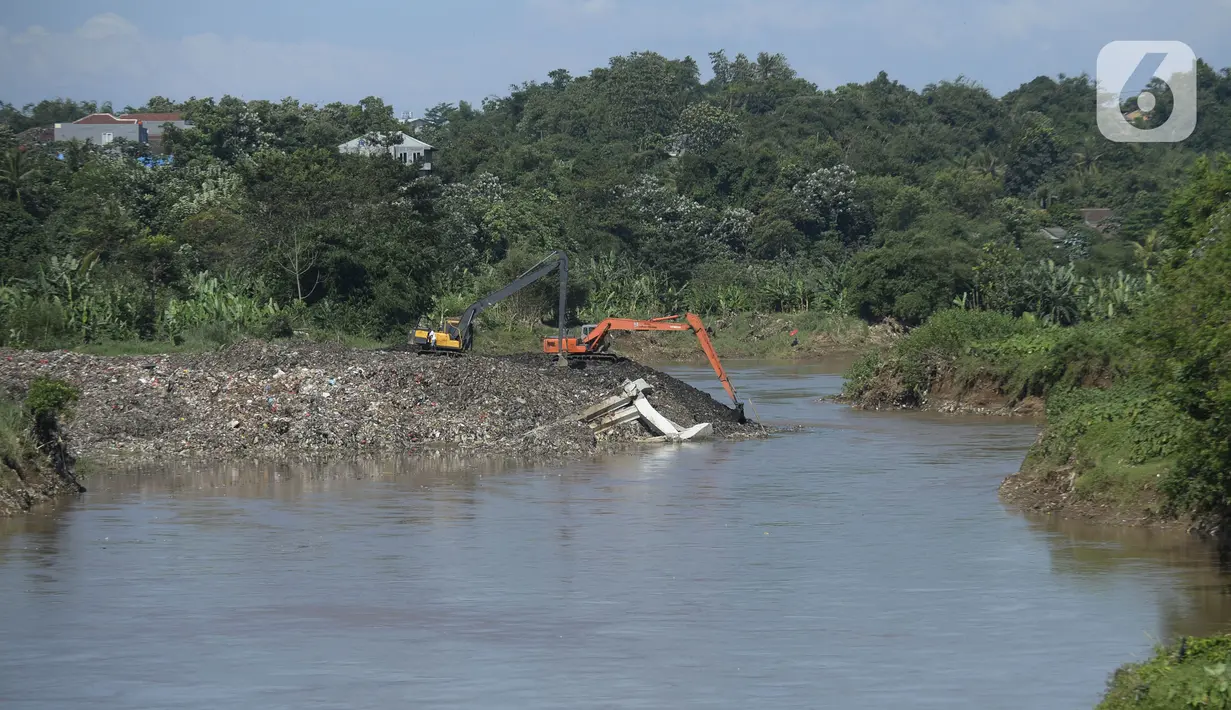 Pekerja menggunakan alat berat mengeruk sampah yang longsor di TPA Cipeucang, Serpong, Tangerang Selatan, Banten, Sebtu (23/5/2020). Turap penahan sampah TPA Cipeucang longsor pada 22 Mei 2020 dan hampir menutupi aliran Sungai Cisadane yang berada di sebelahnya. (merdeka.com/Dwi Narwoko