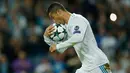 Pemain Real Madrid, Cristiano Ronaldo mencium bola setelah mencetak gol lewat penalti pada laga lanjutan babak penyisihan Grup H Liga Champions di Santiago Bernabeu, Selasa (17/10). Madrid ditahan imbang tamunya Tottenham Hotspur 1-1.  (AP/Francisco Seco)