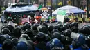 Unjuk rasa ini untuk memprotes meningkatnya angka kejahatan, korupsi, dan impunitas di Meksiko. Tampak dalam foto, seorang pengunjuk rasa memegang bendera berlogo manga populer Jepang, One Piece, simbol yang diadopsi oleh gerakan protes Gen Z di seluruh dunia, di depan barisan polisi di sepanjang Reforma Avenue dalam sebuah demonstrasi yang dilakukan oleh anak muda Meksiko terkait dengan gelombang protes global Generasi Z terhadap pemerintahan Presiden Meksiko, Claudia Sheinbaum, di Mexico City, pada 20 November 2025. (Yuri CORTEZ/AFP)