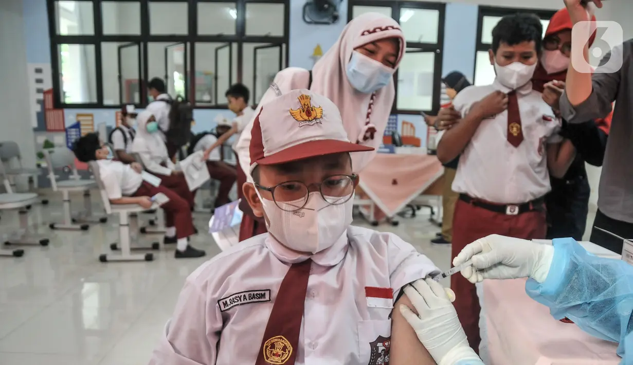 Seorang murid menjalani vaksinasi COVID-19 di SDN Cempaka Putih Timur 03 Pagi, Jakarta, Selasa (14/12/2021). Pemerintah menyiapkan 58 juta dosis vaksin COVID-19 untuk anak usia 6-11 tahun. (merdeka.com/Iqbal S. Nugroho)