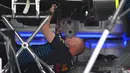 Seorang mekanik bekerja di bawah mobil pembalap Red Bull Racing asal Belanda, Max Verstappen di Shanghai pada 18 April 2024. (GREG BAKER/AFP)