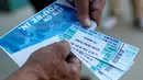Gary Ferman menujukkan tiket pemakaman petinju legendaris Muhammad Ali yang didapat di Freedom Hall, Louisville, Kentucky, Selasa (7/6). Keluarga menyiapkan 14.000 tiket untuk acara pemakaman Muhammad Ali pada 10 Juni mendatang. (REUTERS/John Sommers II)