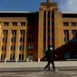 Seorang pria berjalan di sekitar Circular Quay, Sydney, Australia, Selasa (13/7/2021). Lima juta penduduk Sydney akan berada dalam lockdown COVID-19 untuk dua minggu lagi. (Brendon THORNE/AFP)