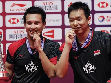 Pasangan ganda putra Mohammad Ahsan/Hendra Setiawan berpose dengan trofi dan medali seusai mengalahkan Hiroyuki Endo/Yuta Watanabe dari Jepang pada final BWF World Tour Finals 2019 di Tianhe Gymnasium, Guangzhou, China (15/12/2019). Ahsan/Hendra menang  24-22, 21-19.  (AP Photo/Andy Wong)