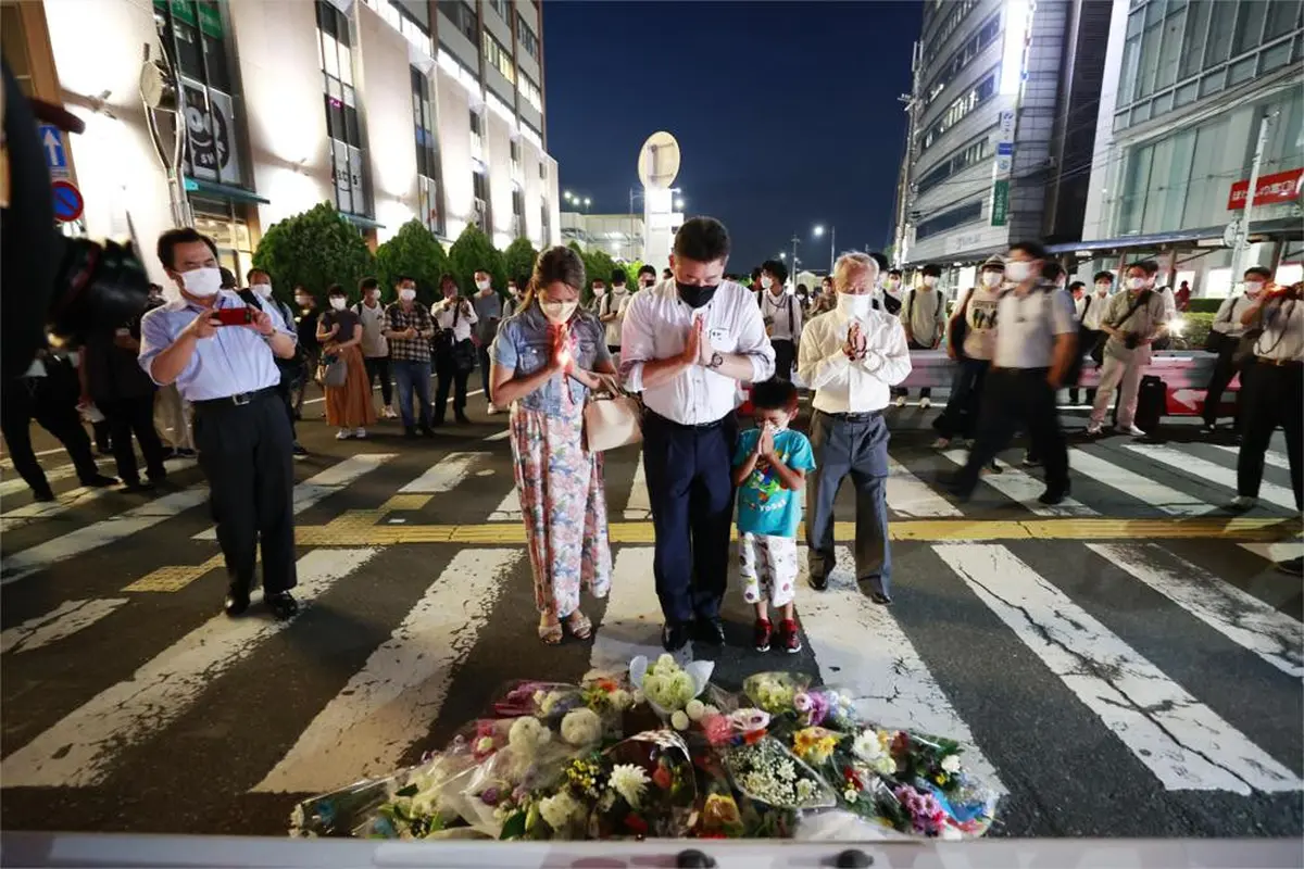 Orang-orang berdoa di lokasi mantan Perdana Menteri Jepang Shinzo Abe ditembak saat pidato di Nara, Jumat, 8 Juli 2022. (Kyodo News via AP)