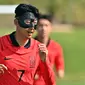 Kapten timnas Korea Selatan Son Heung-min mengenakan masker pelindung saat mengikuti sesi latihan menjelang dimulainya Piala Dunia 2022 Qatar, di Al Egla Training Site 5 di Doha, Rabu (16/11/2022). Son tampil dengan topeng, yang tampaknya terbuat dari serat karbon yang biasa digunakan dalam beberapa tahun terakhir. (Jung Yeon-je / AFP)