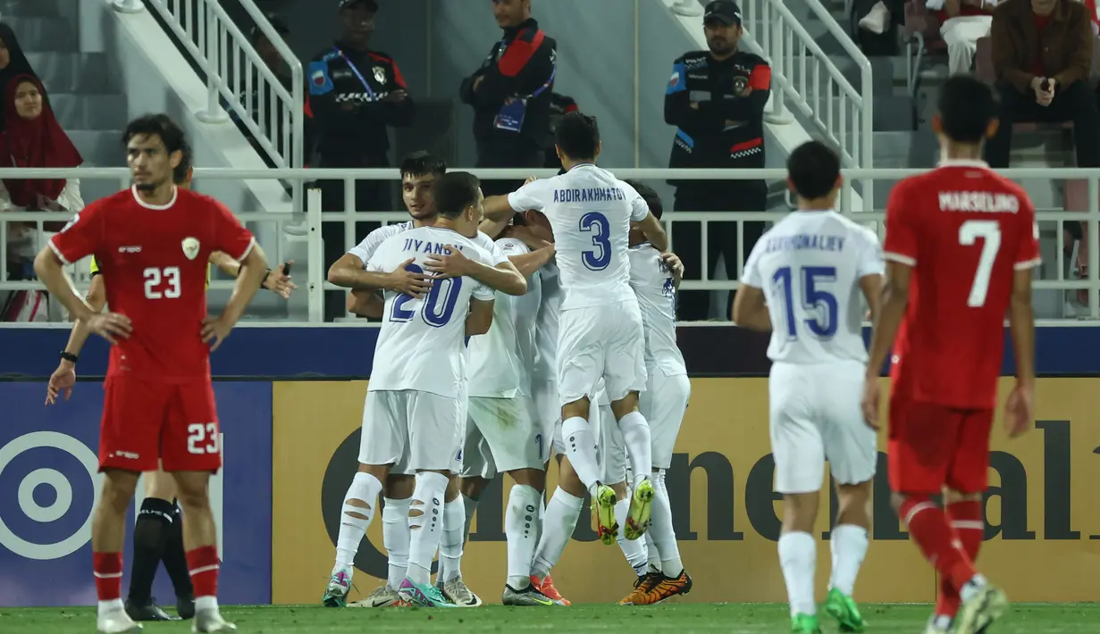 Para pemain Uzbekistan melakukan selebrasi setelah gol bunuh diri yang dicetak oleh Indonesia saat pertandingan semifinal Piala Asia U-23 Qatar 2024 melawan Indonesia di Stadion Abdullah Bin Khalifa di Doha pada 29 April 2024. (KARIM JAAFAR/AFP)