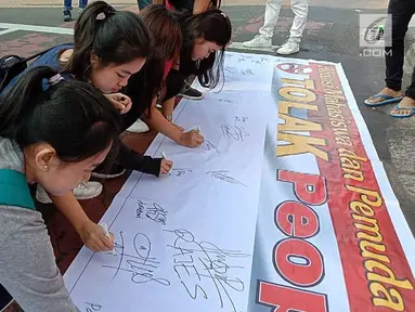 Masyarakat menandatangi spanduk petisi menolak gerakan people power saat car free day (CFD) di kawasan Thamrin, Jakarta, Minggu (19/5/2019). Aliansi Mahasiswa dan Pemuda Cinta NKRI mengajak masyarakat menandatangani petisi mendukung KPU dan Bawaslu pasca Pilpres 2019. (Liputan6.com/Faizal Fanani)