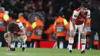 Pemain Arsenal tertenduk lesu usai pertandingan melawan Olympiakos pada leg kedua babak 32 besar Liga Europa di stadion Emirates, London, Kamis (27/2/2020).  Olympiakos menang 2-1 dan lolos dengan unggul agregat gol tandang 2-2. (AP Photo/Frank Augstein)